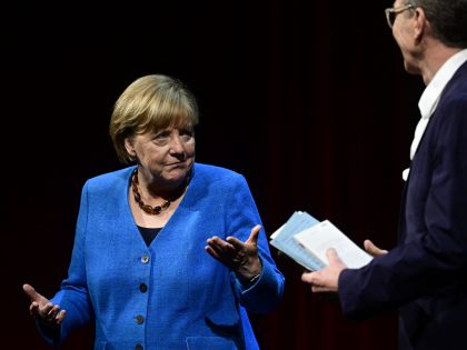 Former German Chancellor Angela Merkel (L) and German journalist Alexander Osang react as they arrive on stage for Merkel's first public talk since stepping down, at the Berliner Ensemble theatre in Berlin on June 7, 2022. (Photo by John MACDOUGALL / AFP) (Photo by JOHN MACDOUGALL/AFP via Getty Images)
