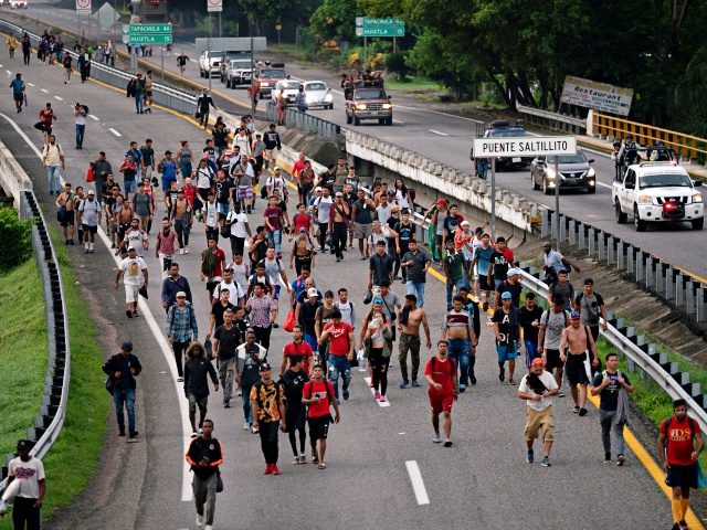 Migrants taking part in a caravan heading to the US, walk from Huixtla to Escuintla, Chiapas state, Mexico, on June 9, 2022. - Thousands of mostly Venezuelan migrants began receiving temporary Mexican visas Wednesday as they prepared to continue their trek toward the United States. The migrants had set up …