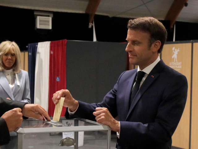 France's President Emmanuel Macron casts his ballot next to his wife Brigitte Macron durin