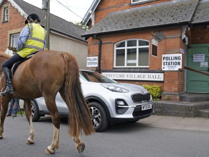 A person on a horse passes the polling station at Uffculme Village Hall, Uffculme, as vote