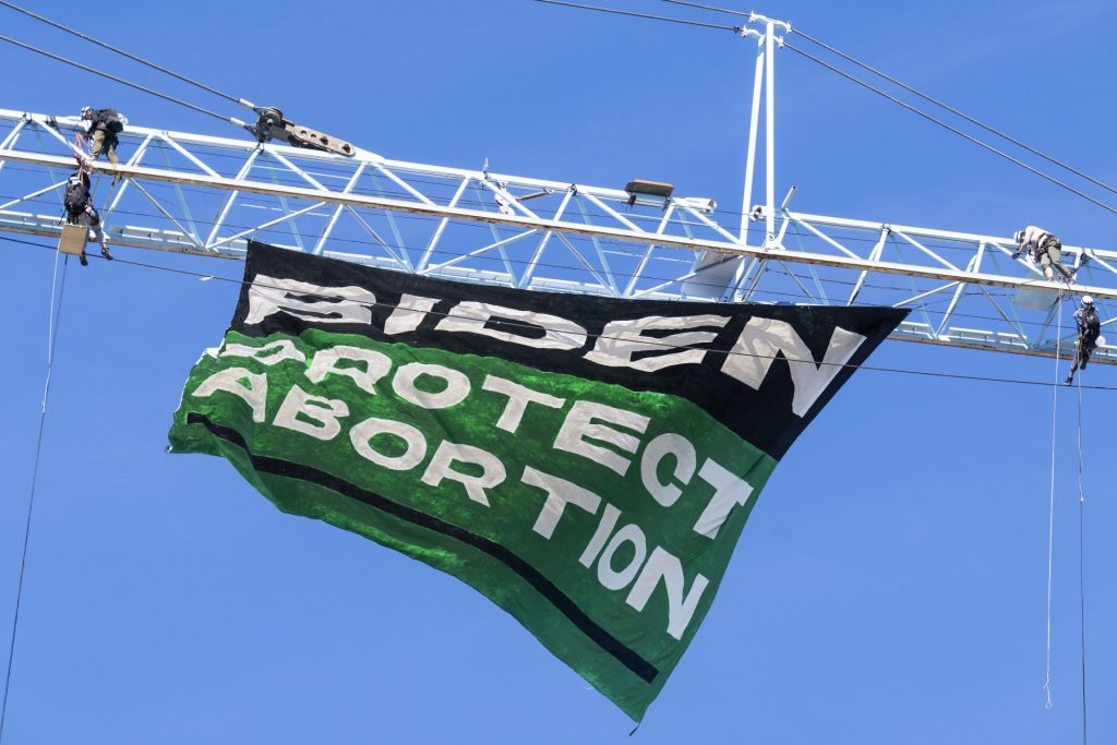 Protesters hang a banner reading Biden Protect Abortion, from a crane at a construction site at North Capitol Street and Florida Avenue NE, in the NoMa neighborhood on Tuesday, June 28, 2022. (Tom Williams/CQ-Roll Call, Inc via Getty Images)