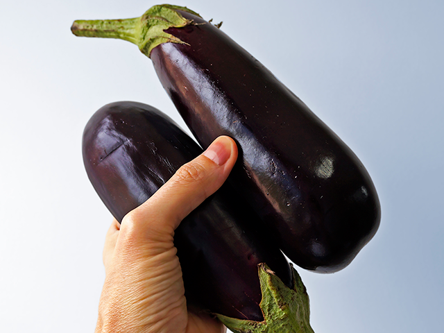 2 eggplants in man's hand