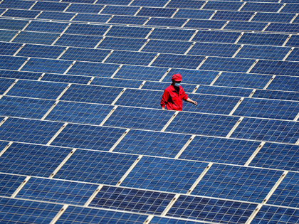 A technician inspects a photovoltaic (PV) system on the roofs of a factory on May 4, 2022