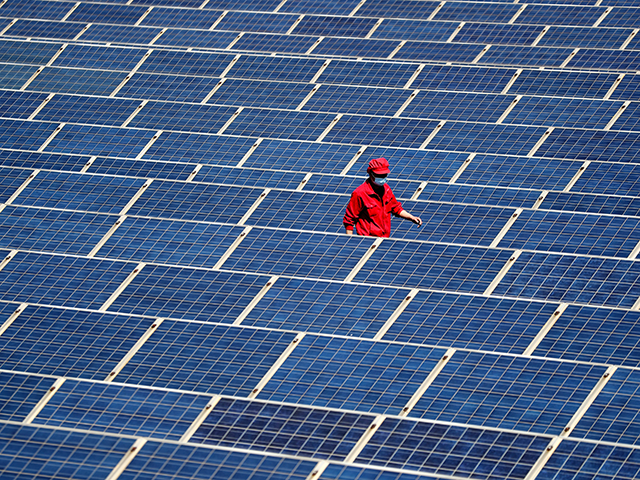 A technician inspects a photovoltaic (PV) system on the roofs of a factory on May 4, 2022 in Qingdao, Shandong Province of China. (Photo by Zhang Jingang/VCG via Getty Images)