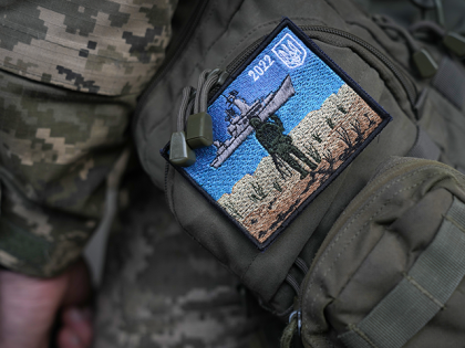 A Ukrainian soldier wears a "Snake Island" embroidered badge on his uniform commemorating the moment when a Ukrainian soldier defiantly replied "Russian warship, go f*ck yourself!' when ordered to surrender, on May 17, 2022 in Kyiv, Ukraine. Following Russia's retreat from areas around the Ukrainian capital, signs of normal life …