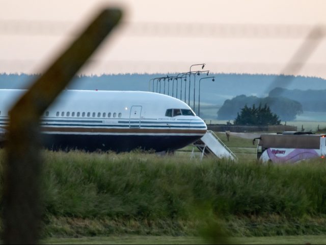 AMESBURY, WILTSHIRE - JUNE 14: A coach pulls up to the Rwanda deportation flight EC-LZO Boeing 767 at Boscombe Down Air Base, on June 14, 2022 in Boscombe Down. The Court of Appeal yesterday rejected a legal bid to stop a Home Office flight taking asylum seekers from the UK …