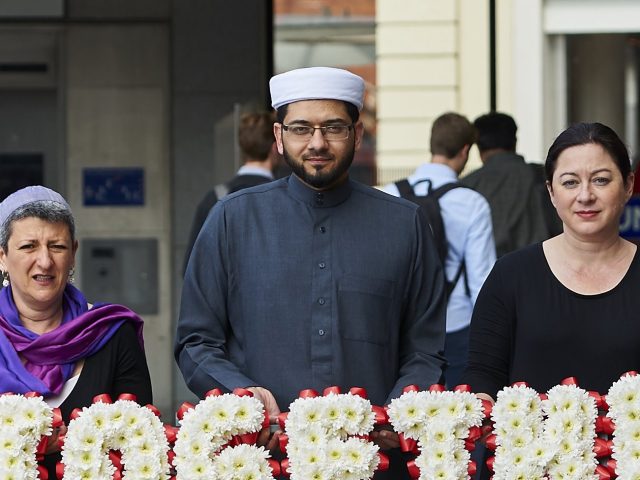 Faith leaders pose for pictures during an event to promote religious unity in central Lond