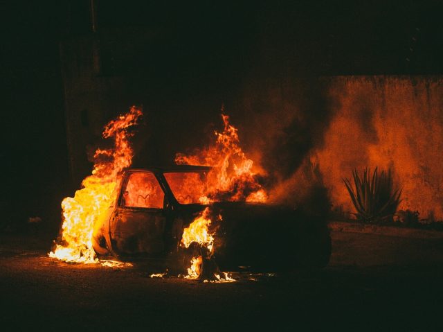 Abandoned car on fire in the dark