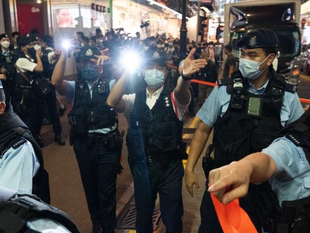 Police officers disperse members of the media at the Causeway Bay area outside Victoria Pa