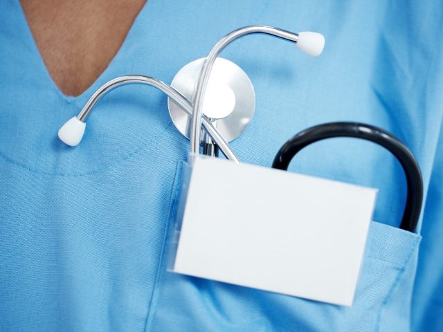 Cropped image of a stehoscope in a doctor's pocket with a blank ID badge in front of it