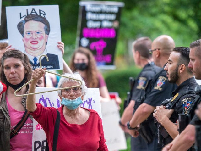 CHEVY CHASE, MD - MAY 18: Police officers look on as abortion-rights advocates hold a demo