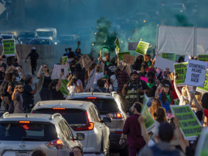 LOS ANGELES, CA - JUNE 24: Green smoke rises as protesters march northbound on the 110 Freeway as they denounce todays US Supreme Court decision overturning "Roe v Wade" on June 24, 2022 in downtown Los Angeles, United States. The US Supreme Court ended the right to abortion in a …