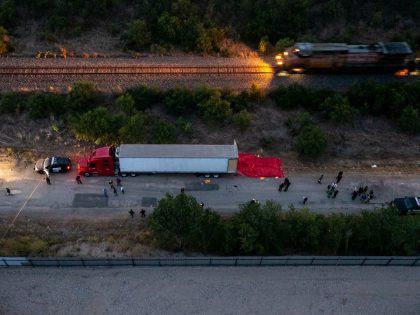 SAN ANTONIO, TX - JUNE 27: In this aerial view, members of law enforcement investigate a tractor trailer on June 27, 2022 in San Antonio, Texas. According to reports, at least 46 people, who are believed migrant workers from Mexico, were found dead in an abandoned tractor trailer. Over a …