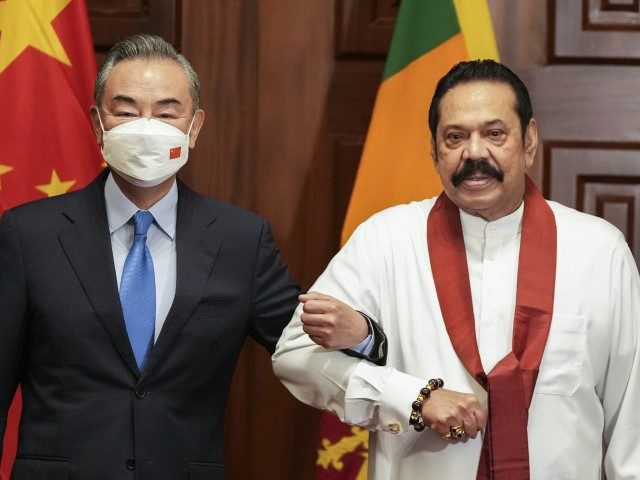 Chinese Foreign Minister Wang Yi, left, poses for media before his meeting with Sri Lankan Prime Minister Mahinda Rajapaksa in Colombo, Sri Lanka, Sunday, January 9, 2022. (Eranga Jayawardena/AP)
