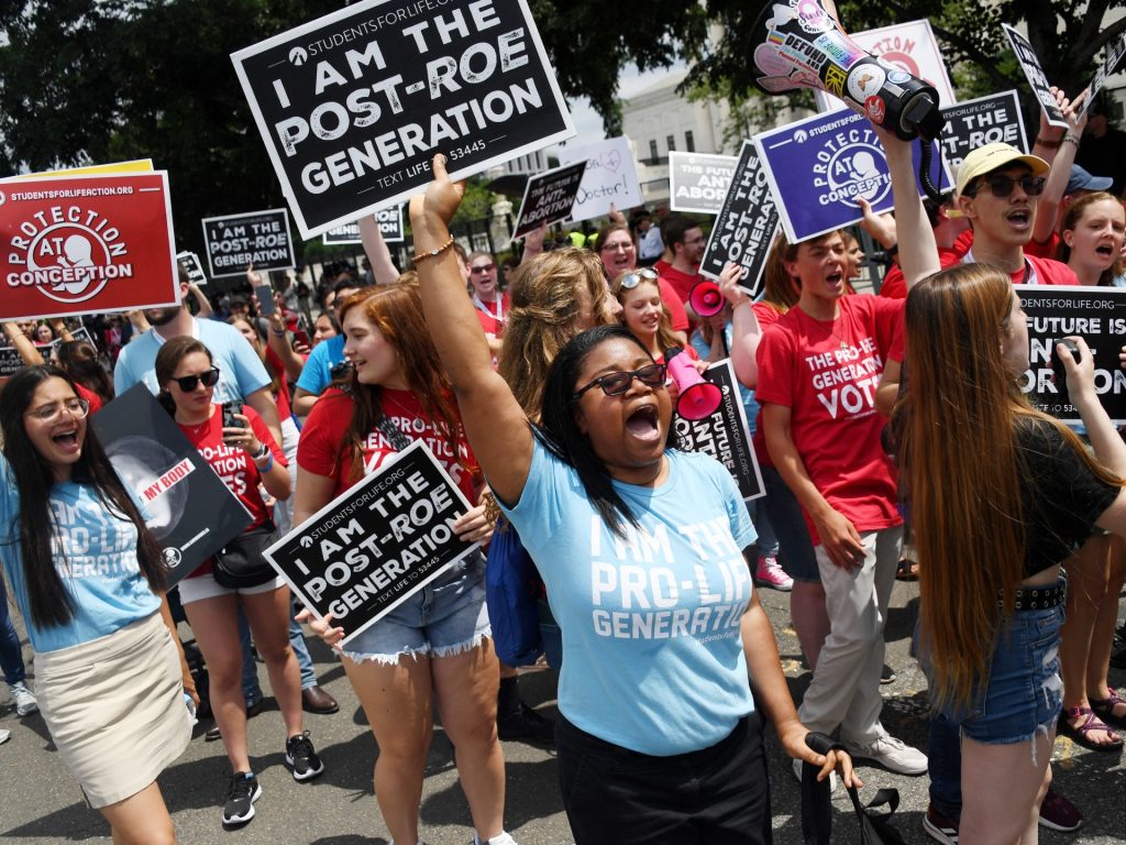 Anti-abortion campaigners celebrate near the US Supreme Court in the streets of Washington, DC, on June 24, 2022. - The US Supreme Court on Friday ended the right to abortion in a seismic ruling that shreds half a century of constitutional protections on one of the most divisive and bitterly fought issues in American political life. The conservative-dominated court overturned the landmark 1973 "Roe v Wade" decision that enshrined a woman's right to an abortion and said individual states can permit or restrict the procedure themselves. (Photo by OLIVIER DOULIERY / AFP) (Photo by OLIVIER DOULIERY/AFP via Getty Images)