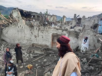 In this photo released by a state-run news agency Bakhtar, Afghans look at destruction cau