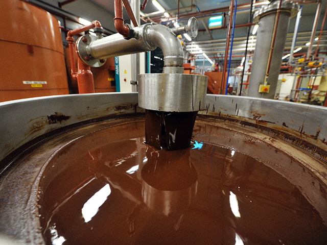 A picture shows hot chocolate before being moulded at the Barry Callebaut chocolate factory in Wieze, Belgium, on July 8, 2013. The industrial group Barry Callebaut buys around a quarter of the world's cocoa bean production and produces 900 tons a day of chocolate. AFP PHOTO / GEORGES GOBET (Photo …