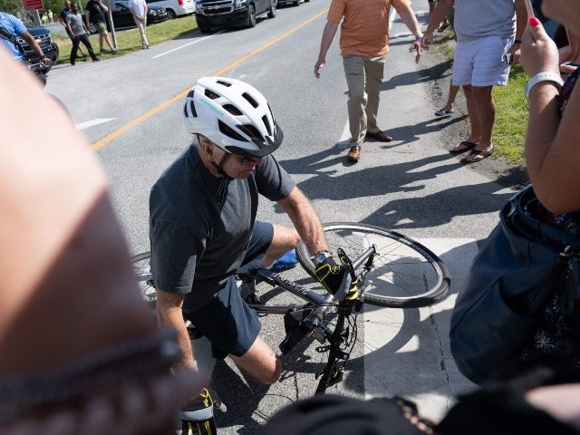 US President Joe Biden falls off his bicycle as he approaches well-wishers following a bike ride at Gordon's Pond State Park in Rehoboth Beach, Delaware, on June 18, 2022. - Biden took a tumble as he was riding his bicycle Saturday morning, but was unhurt. (Photo by SAUL LOEB/AFP via …