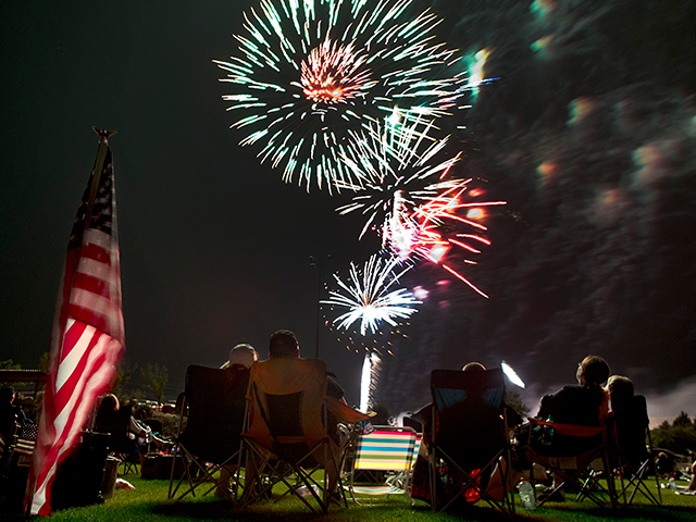 Spectators watch as fireworks explode overhead during the Fourth of July celebration at Pi