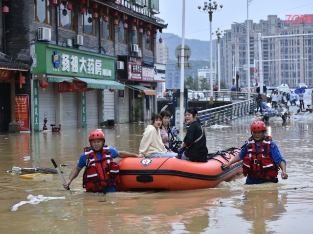 JIAN'OU, CHINA - JUNE 19: Rescuers use rubber boats to evacuate stranded people in flood w