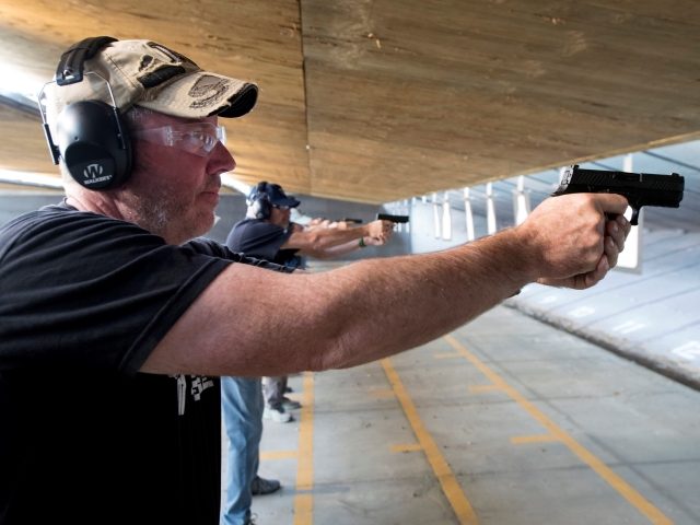 Trainee John Coppin, 53, a dean of a K-6 charter school in Colorado school District 20, fires his pistol during the FASTER Level 2 two day firearms course at Flatrock Training Center in Commerce City, Colorado on August 10, 2019. - FASTER Colorado has been sponsoring firearms training to Colorado …