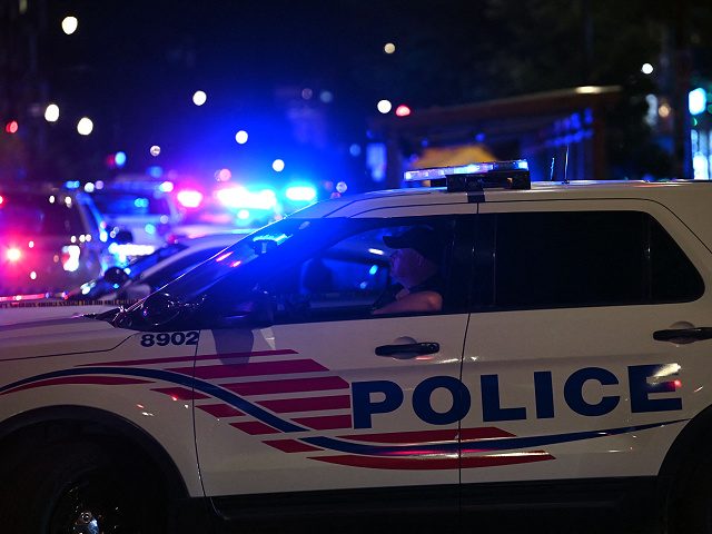 Police cars block a street after a shooting at a restaurant in Washington, DC, on July 22, 2021. (Photo by Brendan SMIALOWSKI / AFP) (Photo by BRENDAN SMIALOWSKI/AFP via Getty Images)