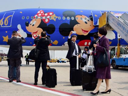 BEIJING, CHINA - APRIL 26: (CHINA OUT) Passengers take pictures with the Disney-themed plane after its debut from Shanghai to Beijing on April 26, 2016 in Beijing, China. The Disney-themed plane, operated by China Eastern Airlines, was painted Mickey and Minnie Mouse on its blue-background body and made its debut …