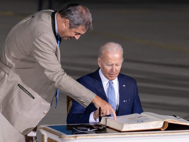 25 June 2022, Bavaria, Munich: Joe Biden (r), President of the USA, signs the Golden Book
