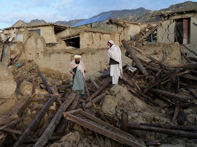 Afghans stand among destruction after an earthquake in Gayan village, in Paktika province,