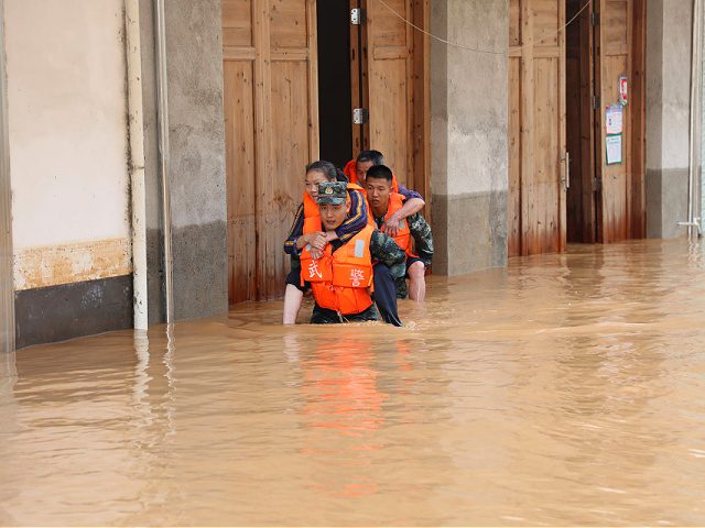 GANZHOU, CHINA - JUNE 06: Armed police officers evacuate residents from a flood-hit area after torrential rains on June 6, 2022 in Ganzhou, Jiangxi Province of China. (Photo by VCG/VCG via Getty Images)
