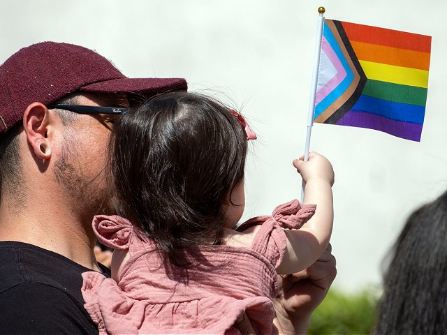 San Fernando, CA - June 01: Louis Salazar hold his daughter Alice, 1-year old, during a Progressive Pride Flag raising ceremony on the steps of San Fernando City Hall on Wednesday, June 1, 2022. In June 2021, the San Fernando City Council adopted a Resolution declaring June as Lesbian, Gay, …