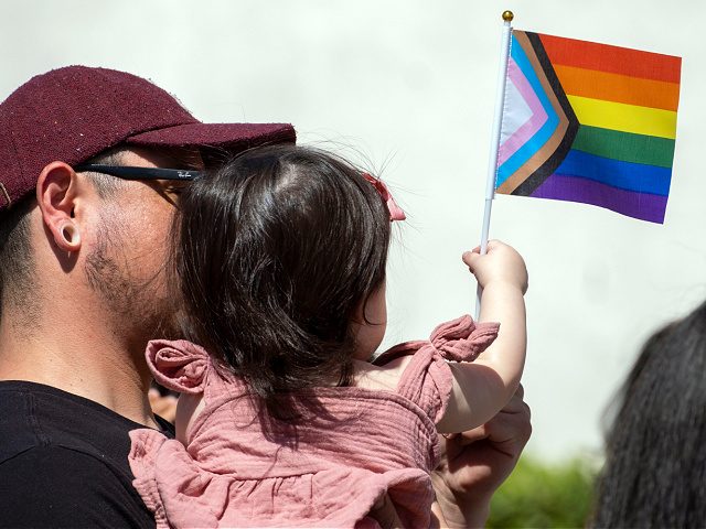 San Fernando, CA - June 01: Louis Salazar hold his daughter Alice, 1-year old, during a Progressive Pride Flag raising ceremony on the steps of San Fernando City Hall on Wednesday, June 1, 2022. In June 2021, the San Fernando City Council adopted a Resolution declaring June as Lesbian, Gay, Bisexual, Transgender and Queer Pride Month (LGBTQ+) in the City of San Fernando. Progressive Pride Flags will be flown at all City facilities and in the Downtown Mall throughout the month of June 2022 to support Pride Month. (Photo by Hans Gutknecht/MediaNews Group/Los Angeles Daily News via Getty Images)