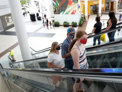 FILE - In this May 29, 2020, file photo, people wearing face masks take an escalator to the second floor of the Arden Fair Mall in Sacramento, Calif. Gov. California's Alameda County said Thursday, June 2, 2022 it will reinstate an indoor mask policy in an effort to ease as …