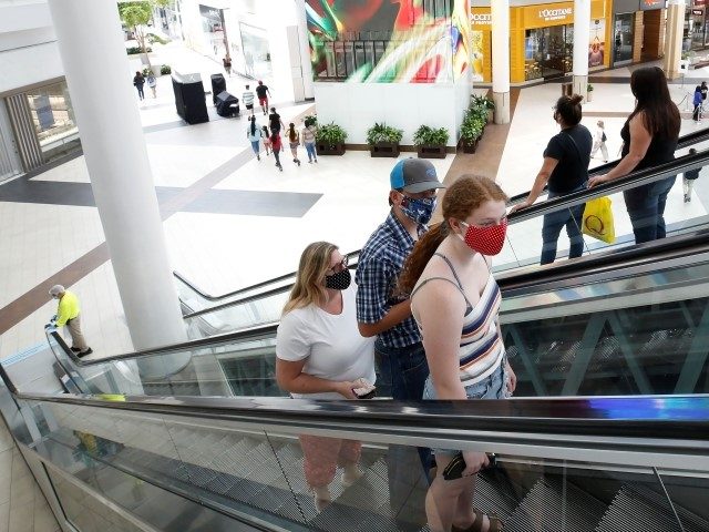 FILE - In this May 29, 2020, file photo, people wearing face masks take an escalator to th