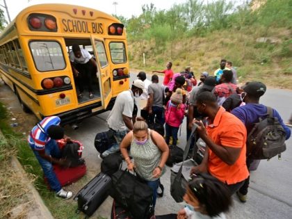 Mostly Haitian migrants prepare to board a bus taking them from a shelter to a US port of