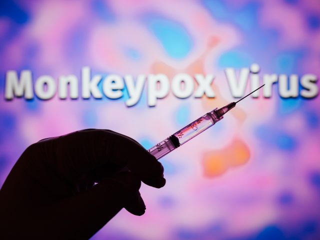 BRAZIL - 2022/05/23: In this photo illustration, a hand holding a medical syringe with the word Monkeypox virus in the background. Monkeypox is a viral disease that occurs mainly in central and western Africa. (Photo Illustration by Rafael Henrique/SOPA Images/LightRocket via Getty Images)