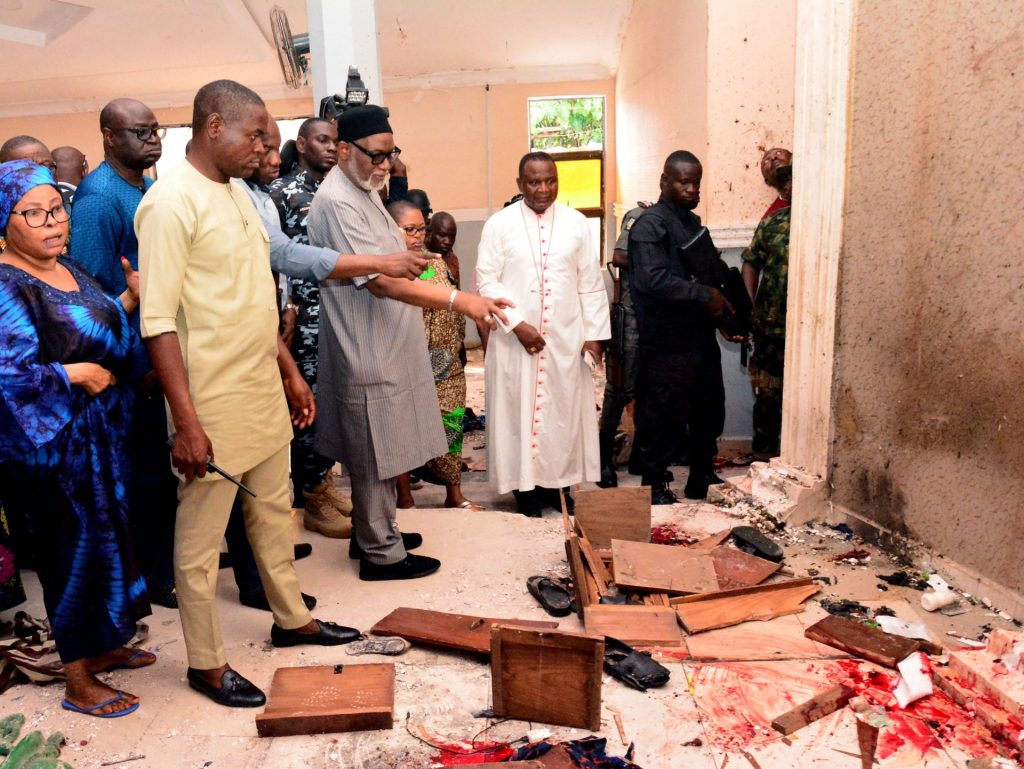 EDITORS NOTE: Graphic content / TOPSHOT - Ondo State governor Rotimi Akeredolu (3rd L) points to blood the stained floor after an attack by gunmen at St. Francis Catholic Church in Owo town, southwest Nigeria on June 5, 2022. - Gunmen with explosives stormed a Catholic church and opened fire in southwest Nigeria on June 5, killing "many" worshippers and wounding others, the government and police said. The violence at St. Francis Catholic Church in Owo town in Ondo State erupted during the morning service in a rare attack in the southwest of Nigeria, where jihadists and criminal gangs operate in other regions. (Photo by AFP) (Photo by -/AFP via Getty Images)