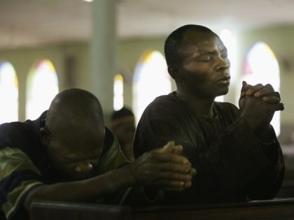 KANO, KANO - APRIL 12: Nigerian Catholic worshipper pray during morning mass April 12, 2005 in Kano, Nigeria. Kano is part of Nigeria's primarily Muslim north, but devoted Catholic minority participates in frequent Masses in local cathedrals. Cardinal Francis Arinze of Nigeria is considered a leading contender to become pope …
