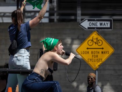 LOS ANGELES, CA - JUNE 26: Sophia Manikas leads a chant from a truck leading a march to de