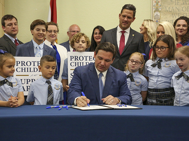 Florida Gov. Ron DeSantis signs the Parental Rights in Education bill at Classical Preparatory school, March 28, 2022 in Shady Hills, Fla. Hundreds of students at a central Florida high school were told they won’t get their yearbooks until they're censored. The principal at Lyman High School says one page is out of compliance with school board policy. It shows images of students holding rainbow flags and a “love is love” sign during a protest of Florida’s Parental Rights in Education Act, otherwise known as the "Don't Say Gay” law. (Douglas R. Clifford/Tampa Bay Times via AP)