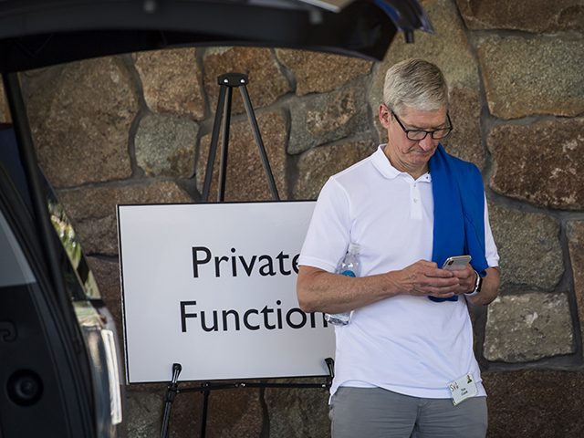 Tim Cook, chief executive officer of Apple Inc., looks at his phone while waiting for a car after the morning session at the Allen & Co. Media and Technology Conference in Sun Valley, Idaho, on July 13, 2018. (David Paul Morris/Bloomberg via Getty Images)