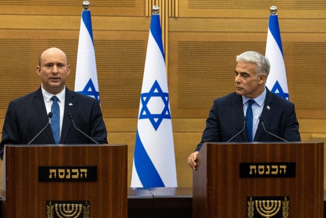 Israel's Prime Minister Naftali Bennett (L) and Foreign Minister Yair Lapid make a joint s