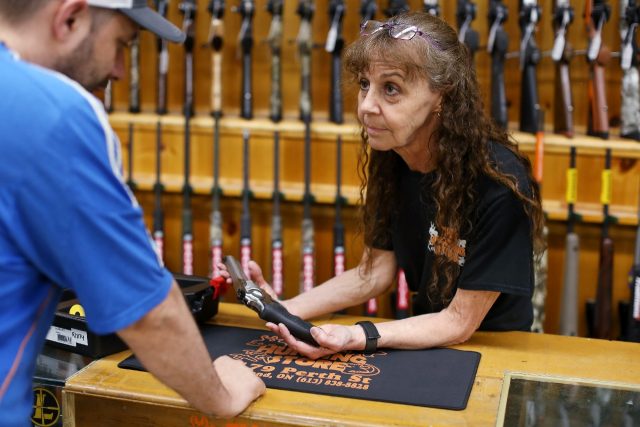 Jen Lavigne (R), co-owner of That Hunting Store in Ottawa, Canada, shows a customer a Ruge