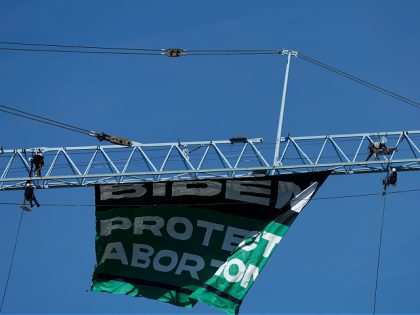 WASHINGTON, DC - JUNE 28: Women's March activists unfurl a banner reading "BIDEN PROTECT ABORTION" from a construction crane near the U.S. Capitol on June 28, 2022 in Washington, DC. The activist group unfurled the banner in response to the U.S. Supreme Court's decision to overturn the landmark 50-year-old Roe …
