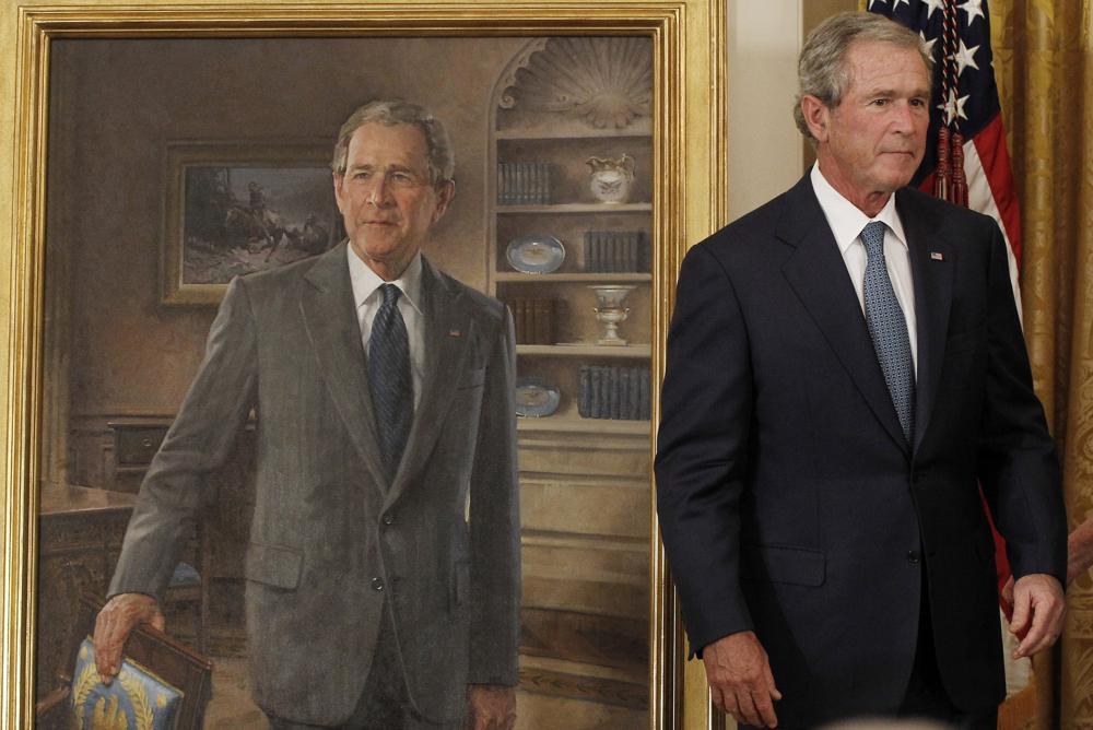 FILE - Former President George W. Bush stands next to his official portrait during the unveiling ceremony in the East Room of the White House in Washington, May 31, 2012. Former President Barack Obama's presidential portrait will be unveiled at the White House in a Sept. 7, 2022, ceremony hosted by President Joe Biden. (AP Photo/Pablo Martinez Monsivais, File)
