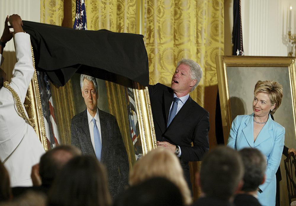FILE - Former President Clinton, center, unveils his portrait as he and former first lady Hillary Clinton, right, participate in a ceremony for the unveiling of the Clinton portraits, June 14, 2004, in the East Room of the White House in Washington. Former President Barack Obama's presidential portrait will be unveiled at the White House in a Sept. 7, 2022, ceremony hosted by President Joe Biden. (AP Photo/Ron Edmonds, File)