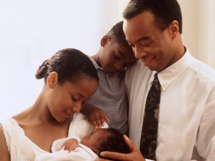 A mother and father with newborn baby and young son