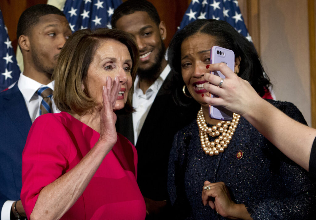 House Speaker Nancy Pelosi, of Calif., has a FaceTime call, standing next to Rep. Jahana Hayes, D-Conn., during ceremonial swearing-in on Capitol Hill in Washington, Thursday, Jan. 3, 2019, at the opening session of the 116th Congress. (AP Photo/Jose Luis Magana)