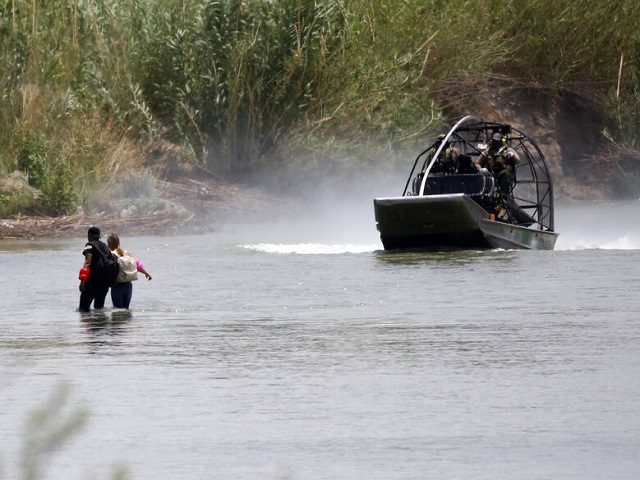 A Border Patrol boat floats near people crossing the Rio Grande river towards the U.S. in Eagle Pass, Texas, Sunday May 22, 2022. The U.S. government has expelled migrants more than 1.9 million times under Title 42, named for a 1944 public health law, denying them a chance to seek …