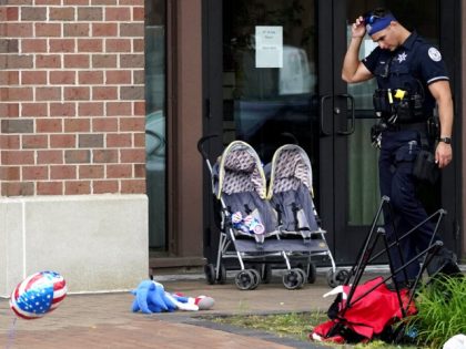 A police officer reacts as he walks in downtown Highland Park, a suburb of Chicago, Monday, July 4, 2022, where a mass shooting took place at a Highland Park Fourth of July parade. (AP Photo/Nam Y. Huh)
